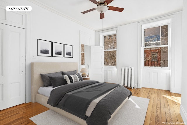 43 Charlton St, New York City, NY 10014 - bedroom featuring light wood finished floors, visible vents, radiator heating unit, a ceiling fan, and a decorative wall