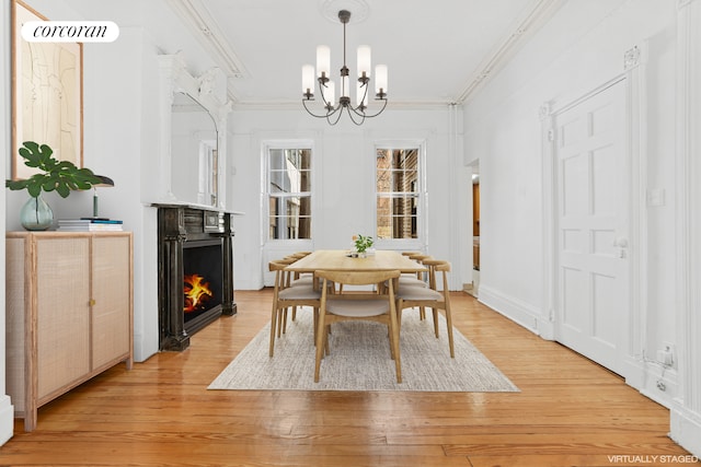 43 Charlton St, New York City, NY 10014 - dining space featuring an inviting chandelier, ornamental molding, a lit fireplace, and light wood-style flooring