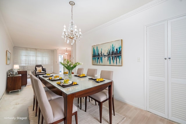 dining room featuring a chandelier, light wood-type flooring, and ornamental molding