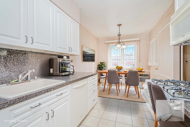 kitchen featuring white appliances, a sink, light tile patterned flooring, decorative backsplash, and white cabinets