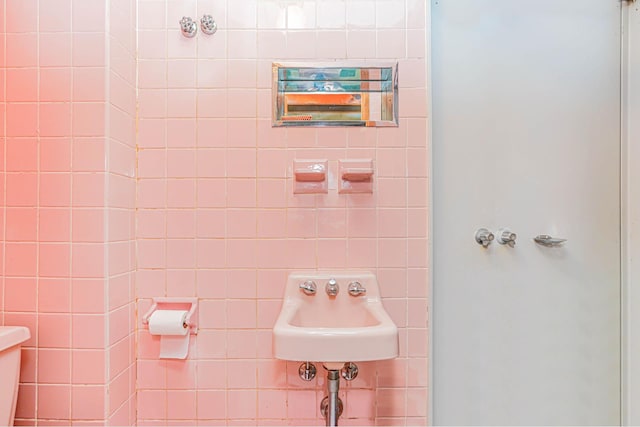 bathroom featuring a walk in shower and a sink
