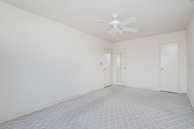 empty room with ceiling fan, light carpet, and baseboards