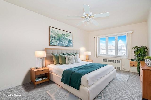 bedroom with radiator, baseboards, light carpet, and ceiling fan