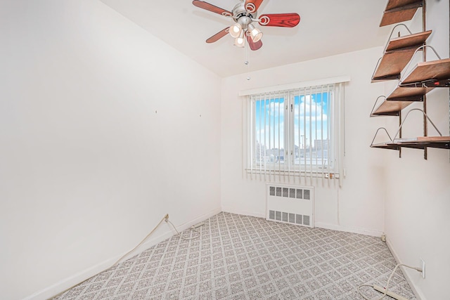 unfurnished room featuring radiator heating unit, a ceiling fan, baseboards, and light carpet