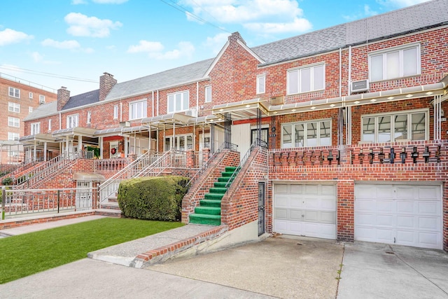 view of property with an attached garage, driveway, and brick siding