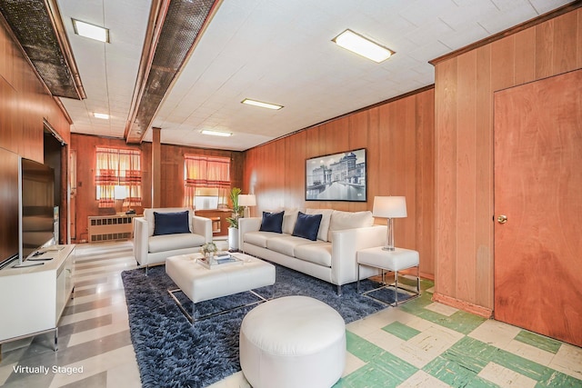 living area with tile patterned floors and wood walls