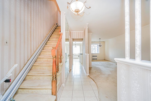 stairs with radiator heating unit, a chandelier, carpet, tile patterned flooring, and baseboards