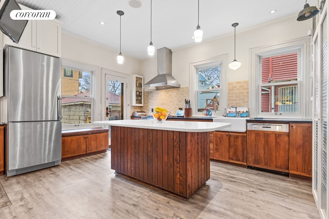 kitchen featuring wall chimney range hood, freestanding refrigerator, light wood-type flooring, and dishwasher
