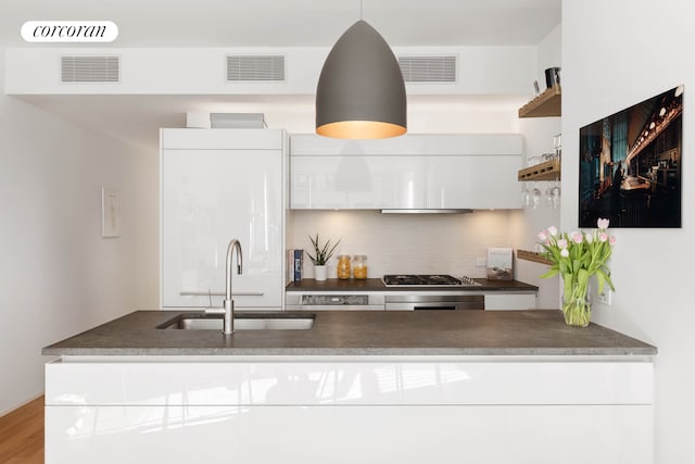 241 5th Ave Unit 10B, New York City, NY 10016 - kitchen with open shelves, backsplash, gas cooktop, white cabinets, and dark countertops