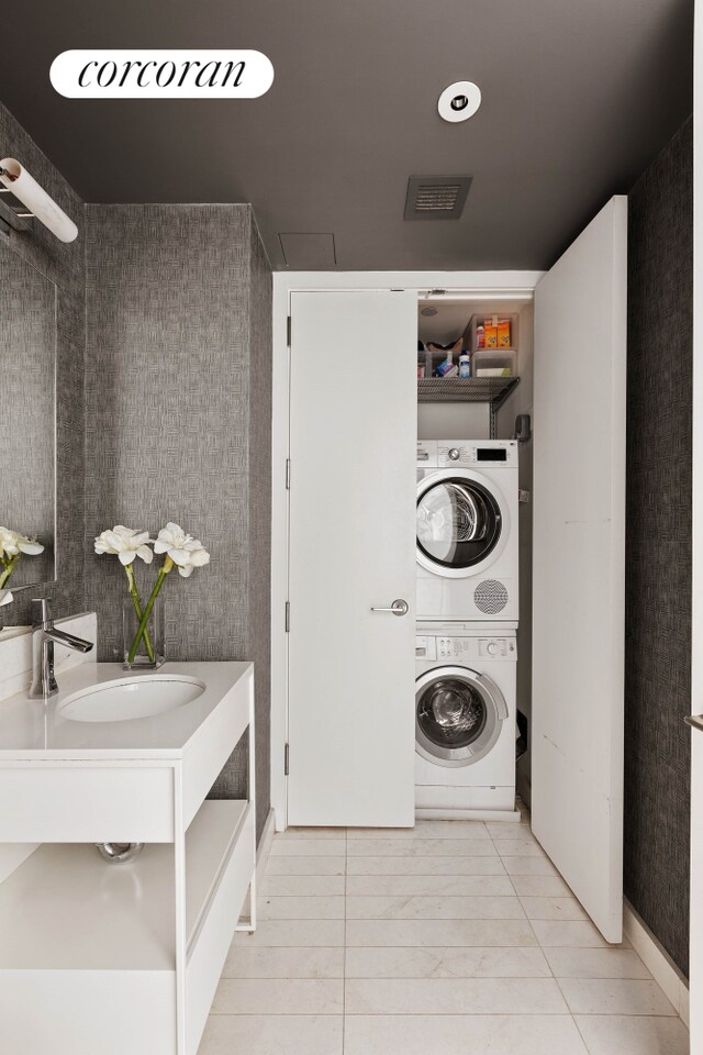 241 5th Ave Unit 10B, New York City, NY 10016 - laundry area with stacked washing machine and dryer and tile patterned flooring