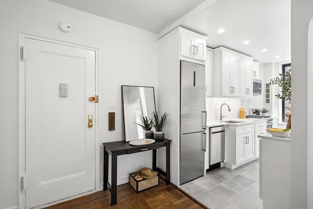 210 W 103rd St Unit 2G, New York City, NY 10025 - kitchen with built in appliances, white cabinets, a sink, light countertops, and recessed lighting