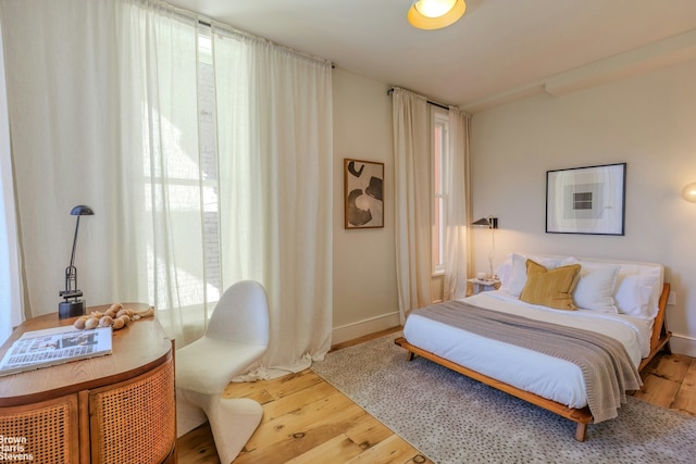bedroom with baseboards and wood finished floors