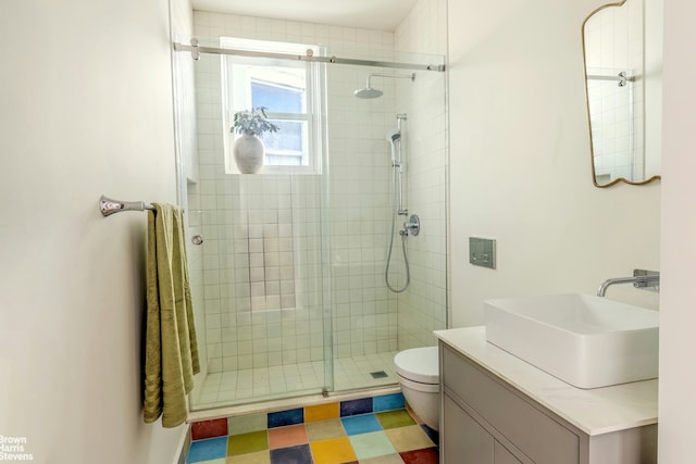 full bath with a shower stall, toilet, vanity, and tile patterned floors