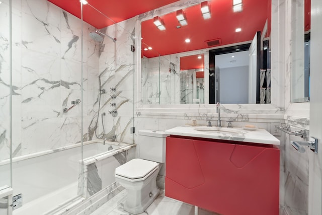 17 W 54th St Unit 6C, New York City, NY 10019 - full bathroom featuring tile walls, toilet, bath / shower combo with glass door, and vanity