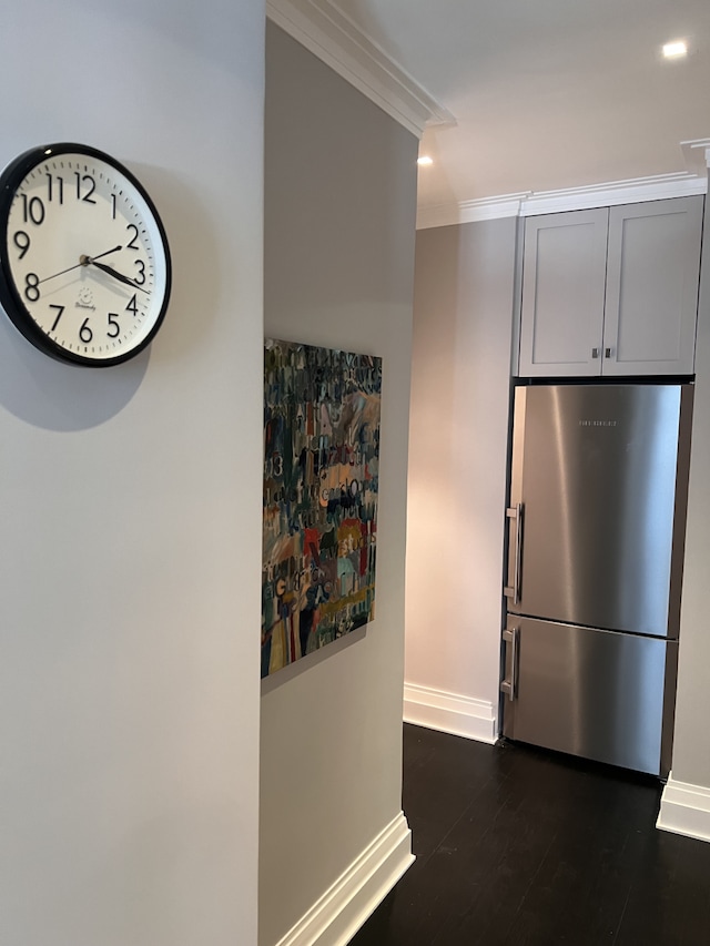 kitchen with freestanding refrigerator, ornamental molding, baseboards, and dark wood-style floors