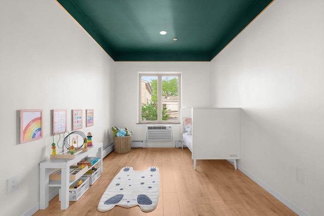 35 E 4th St Unit 3, New York City, NY 11218 - playroom with wood finished floors, a wall mounted AC, a baseboard heating unit, and recessed lighting