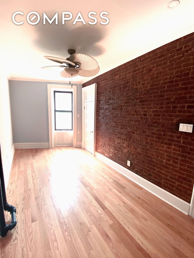 100 Hamilton Pl Unit 2F, New York City, NY 10031 - empty room with baseboards, ceiling fan, wood finished floors, and brick wall