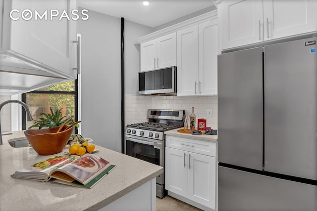 100 Hamilton Pl Unit 2F, New York City, NY 10031 - kitchen featuring stainless steel appliances, tasteful backsplash, white cabinets, light stone counters, and recessed lighting