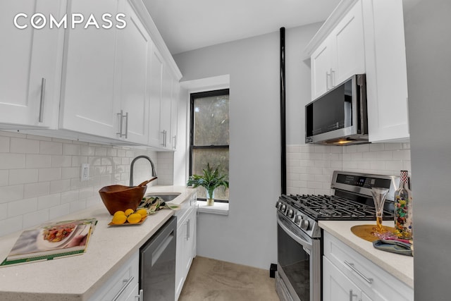 100 Hamilton Pl Unit 2F, New York City, NY 10031 - kitchen featuring appliances with stainless steel finishes, a sink, backsplash, and white cabinets