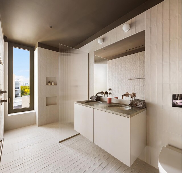 144 Vanderbilt Ave Unit 2C, New York City, NY 11205 - full bathroom with a walk in shower, double vanity, tile patterned floors, and tile walls