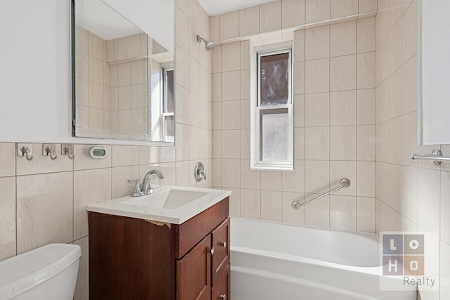 bathroom featuring toilet, tile walls, and vanity