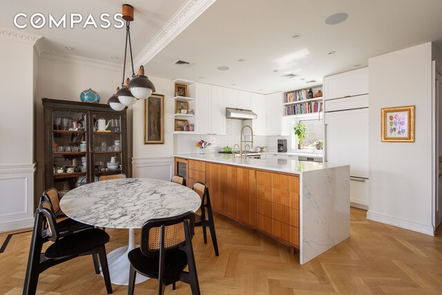 309 W 86th St Ph, Ph, New York City, NY 10024 - kitchen featuring open shelves, under cabinet range hood, a peninsula, light countertops, and ornamental molding