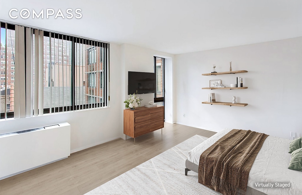 343 E 74th St Unit 7D, New York City, NY 10021 - bedroom featuring wood finished floors and radiator
