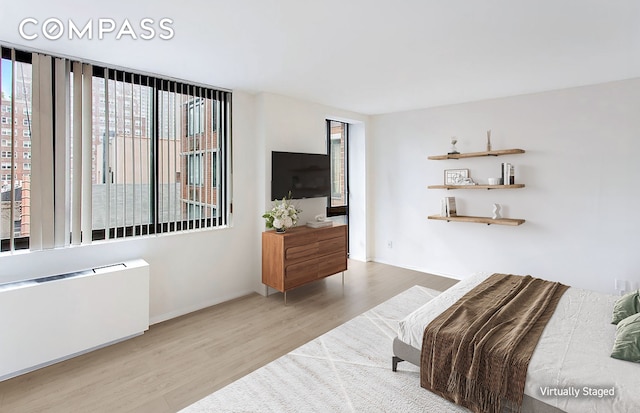 343 E 74th St Unit 7D, New York City, NY 10021 - bedroom featuring wood finished floors and radiator