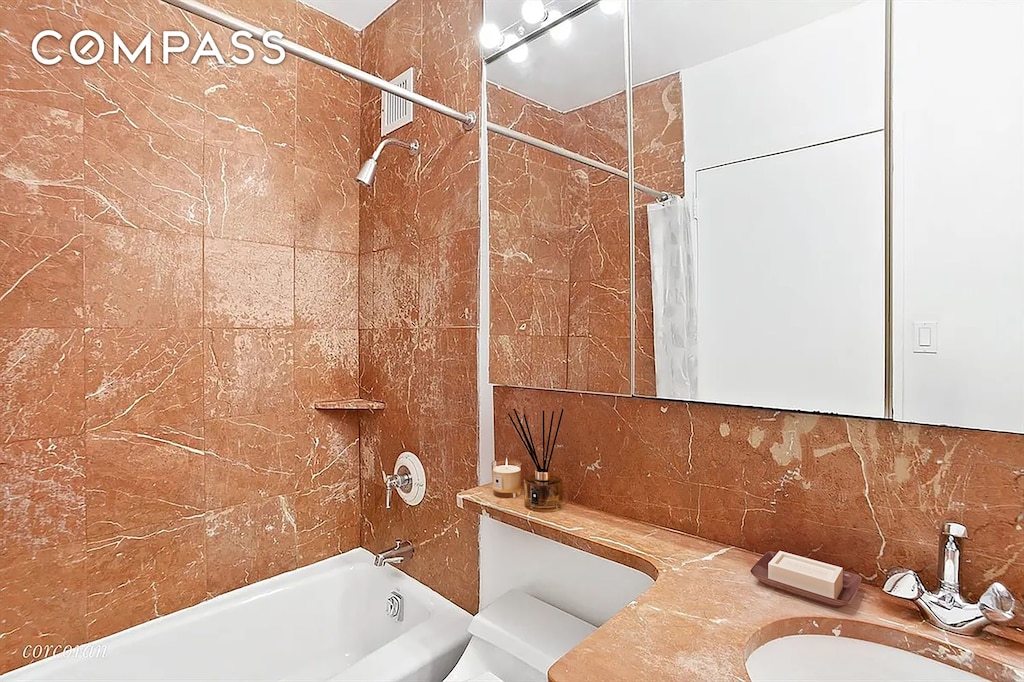 343 E 74th St Unit 7D, New York City, NY 10021 - bathroom featuring tasteful backsplash, shower / tub combo with curtain, and vanity