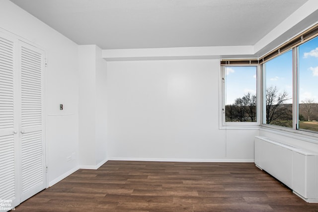 unfurnished bedroom with baseboards, wood finished floors, and a closet