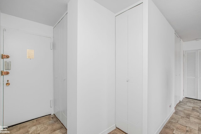 corridor with baseboards and stone finish flooring