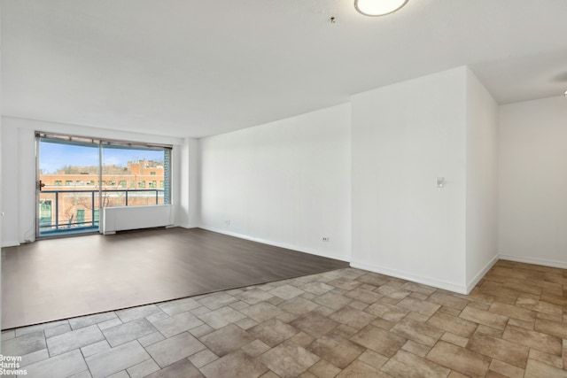 empty room with baseboards and stone finish floor