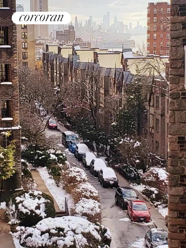 snow covered property with a view of city