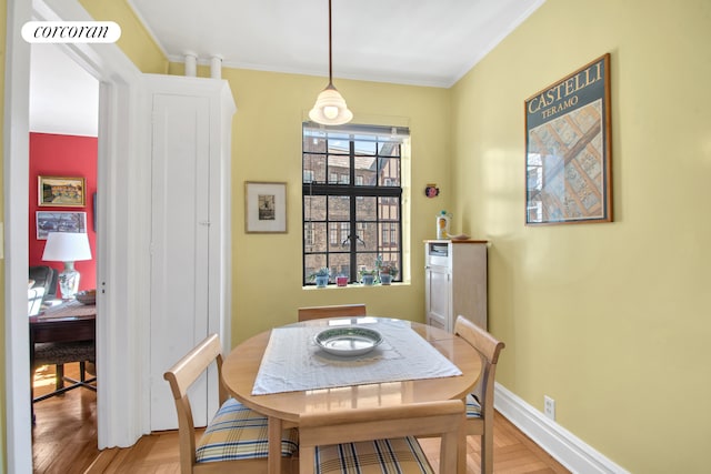 dining space featuring baseboards, ornamental molding, light wood finished floors, and visible vents