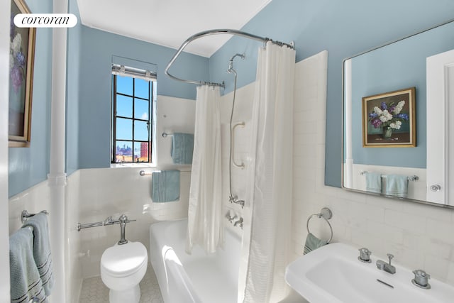 bathroom featuring decorative backsplash, shower / tub combo with curtain, toilet, tile walls, and a sink