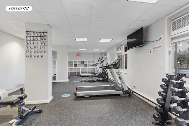 workout area featuring a drop ceiling and baseboards