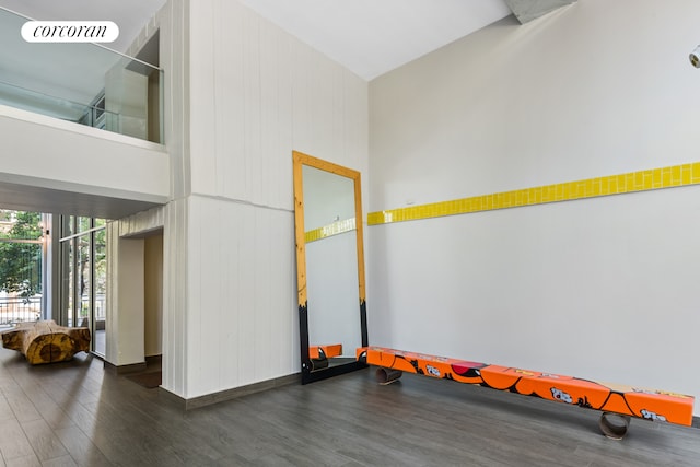 interior space featuring a towering ceiling and wood walls
