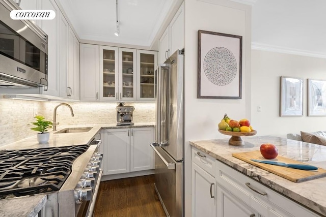 575 Main St Unit 903, New York City, NY 10044 - kitchen featuring stainless steel appliances, a sink, tasteful backsplash, dark wood-style flooring, and light stone counters