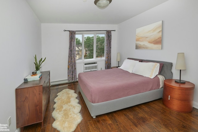 bedroom featuring a baseboard heating unit, a wall mounted air conditioner, and wood finished floors