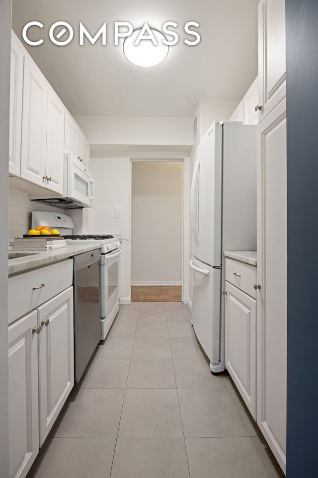 13 W 13th St Unit 6Js, New York City, NY 10011 - kitchen with white appliances, backsplash, and white cabinetry