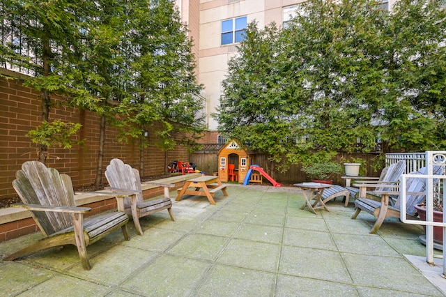 view of patio / terrace with a fenced backyard, a storage shed, and a playground