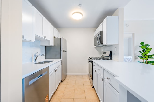 kitchen with decorative backsplash, stainless steel appliances, light countertops, and a sink