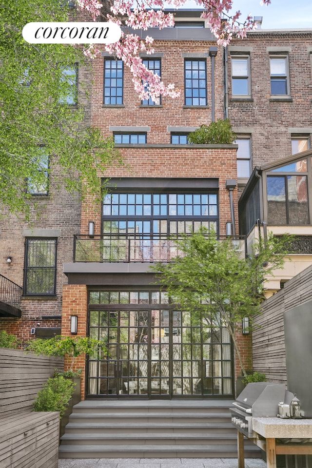 rear view of property with brick siding