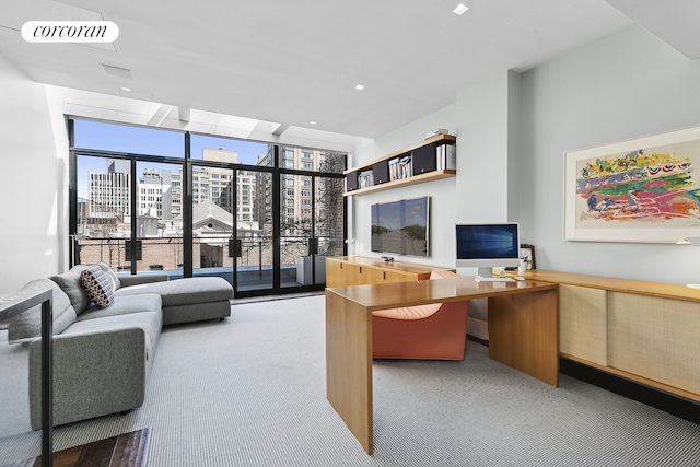 carpeted office featuring visible vents, a wall of windows, and plenty of natural light