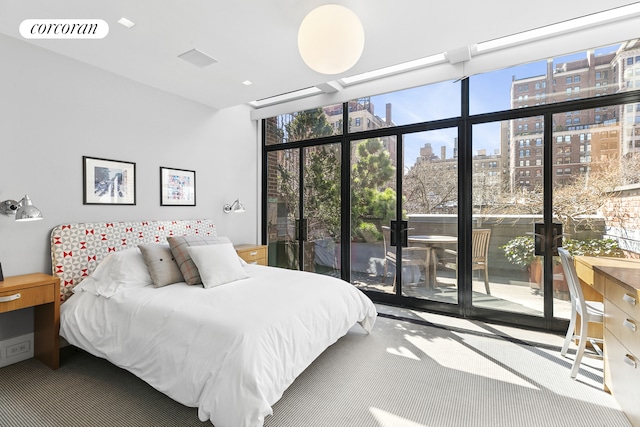 bedroom with multiple windows, visible vents, a view of city, and access to exterior