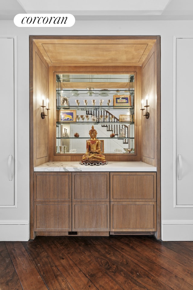 bar featuring a bar and dark wood-style flooring