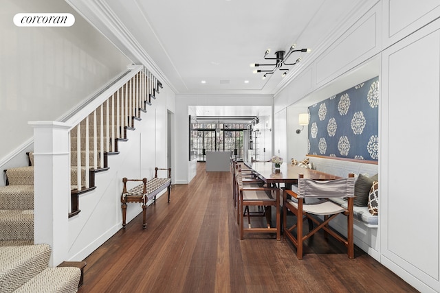 dining area featuring a chandelier, wood finished floors, stairs, and ornamental molding