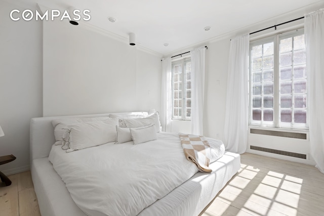 367 Bleecker St Unit 2, New York City, NY 10014 - bedroom with radiator, multiple windows, crown molding, and light wood-style flooring