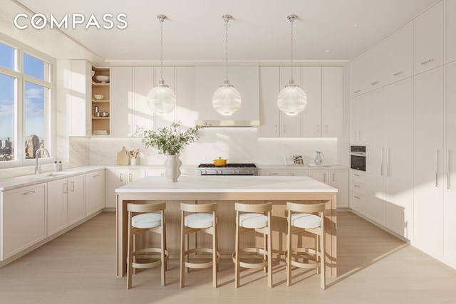 kitchen with oven, light countertops, white cabinets, and a kitchen island