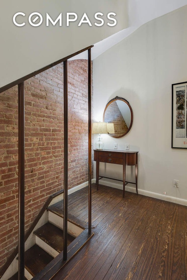 217 W 15th St, New York City, NY 10011 - hallway featuring hardwood / wood-style flooring, baseboards, and brick wall